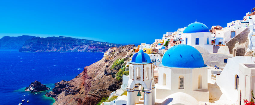 Oia town on Santorini island, Greece. Traditional and famous houses and churches with blue domes over the Caldera, Aegean sea